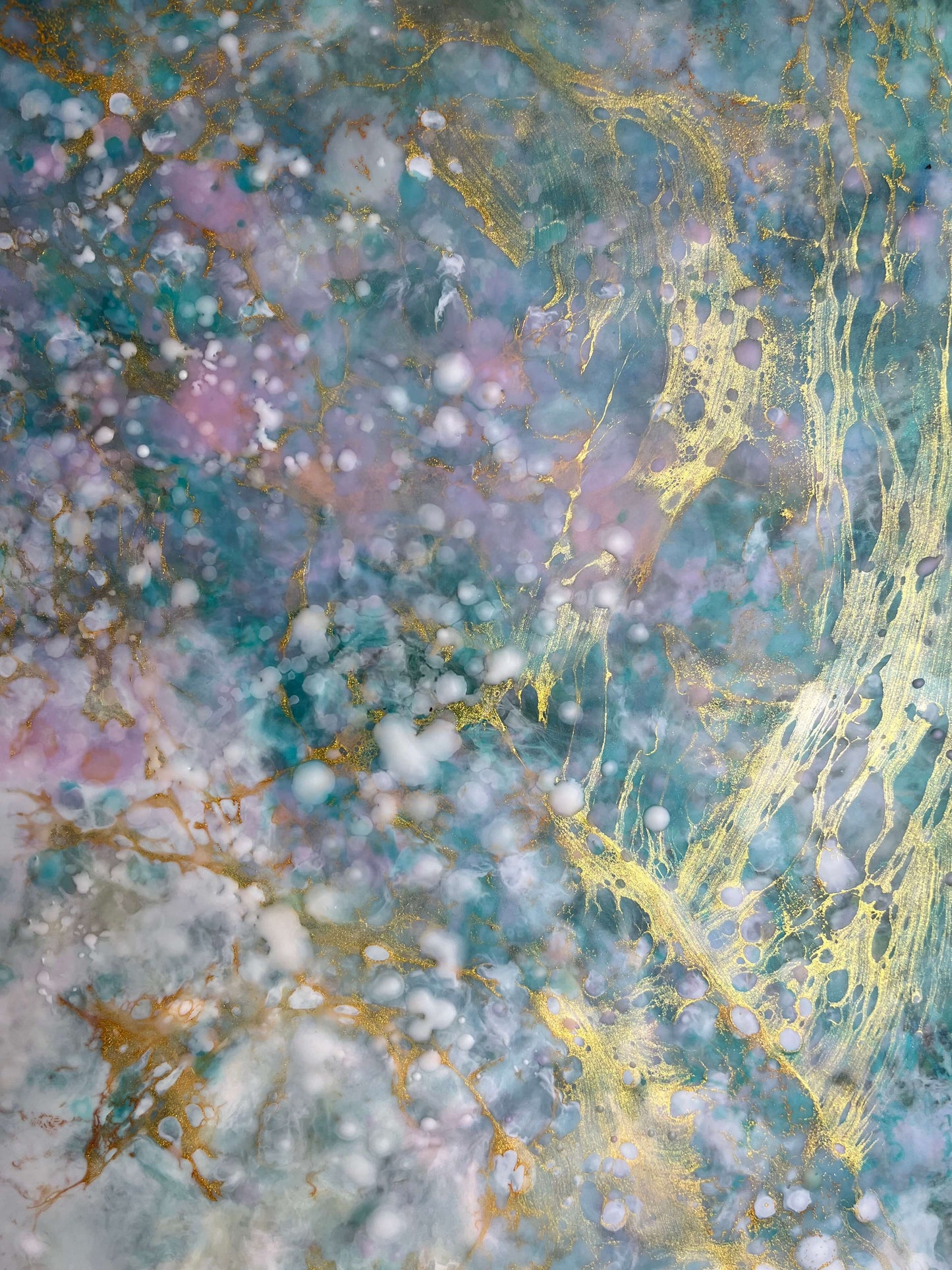 Close up. This abstract painting has a calming feel to it with blue greens, white, pinks and gold. it creates an ethereal feeling with the what looks like a magical cloud floating by.