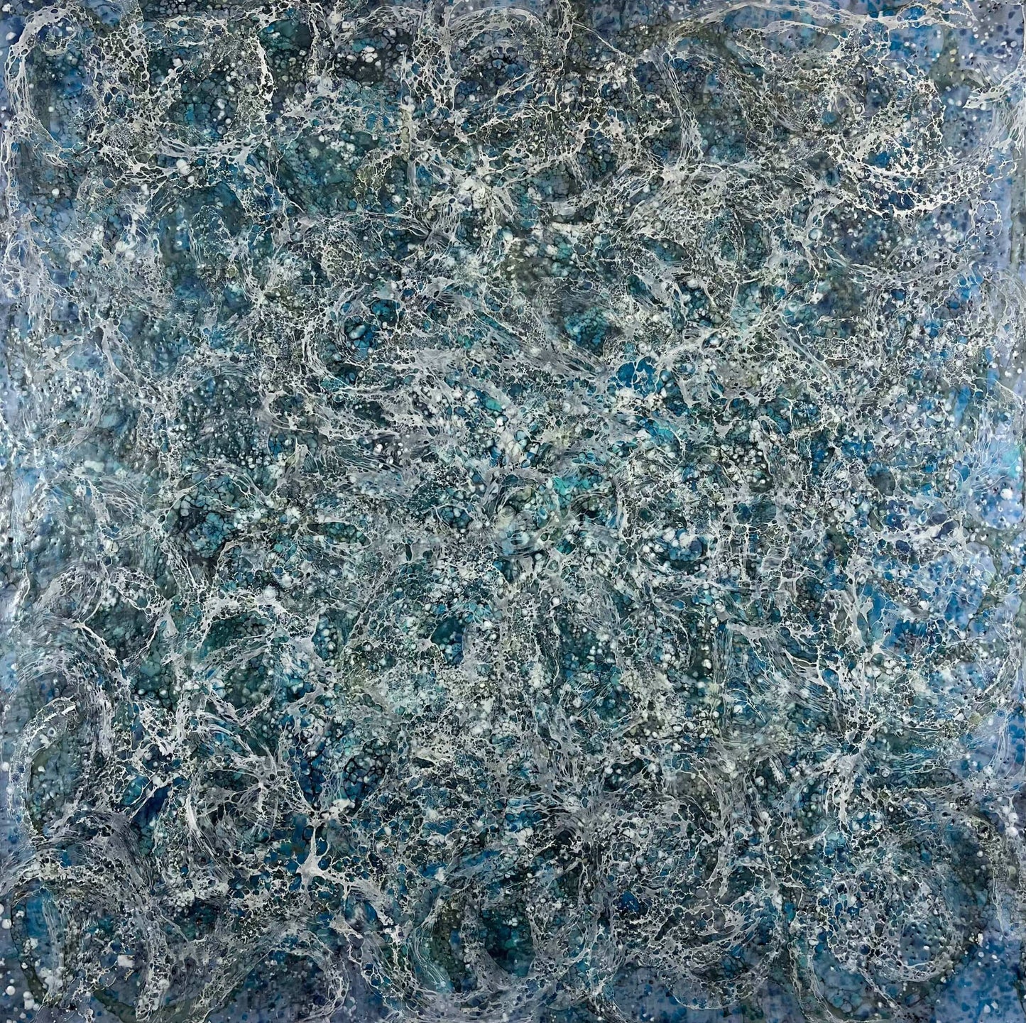 Encaustic abstract painting in blue and white tones with lots of visual texture and many lace-like swirls. Square panel 40x40inches. It is an abstract painting, and it resembles foaming ocean waters as they hit the rocks.