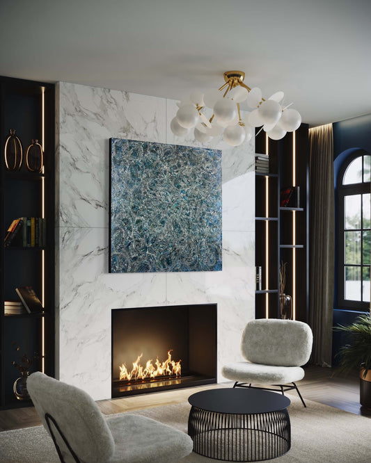 Original abstract encaustic painting in deep blues and white tones with lots of visual texture and many lace-like swirls. Displayed on a marble fireplace wall in a modern living room interior