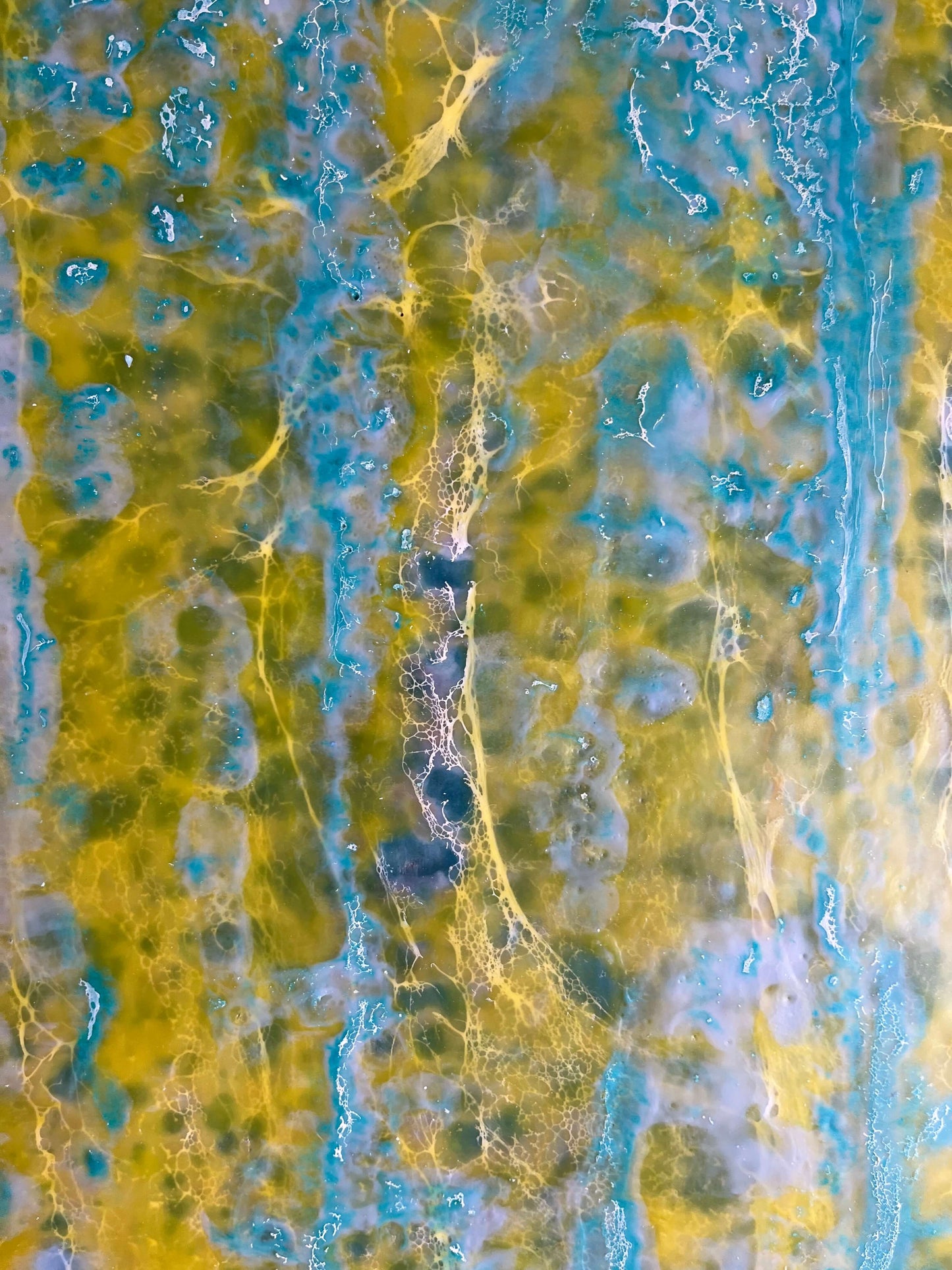 Close up.This abstract painting is reminiscent to me of a wall of an old building that has been weathered with humidity and sun. The greens and yellows are like moss that has developed on the plaster where blue paint has cracked and been peeling.