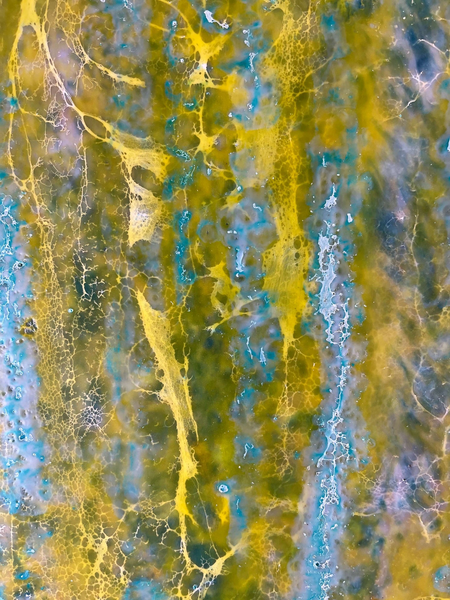 Close up.This abstract painting is reminiscent to me of a wall of an old building that has been weathered with humidity and sun. The greens and yellows are like moss that has developed on the plaster where blue paint has cracked and been peeling.