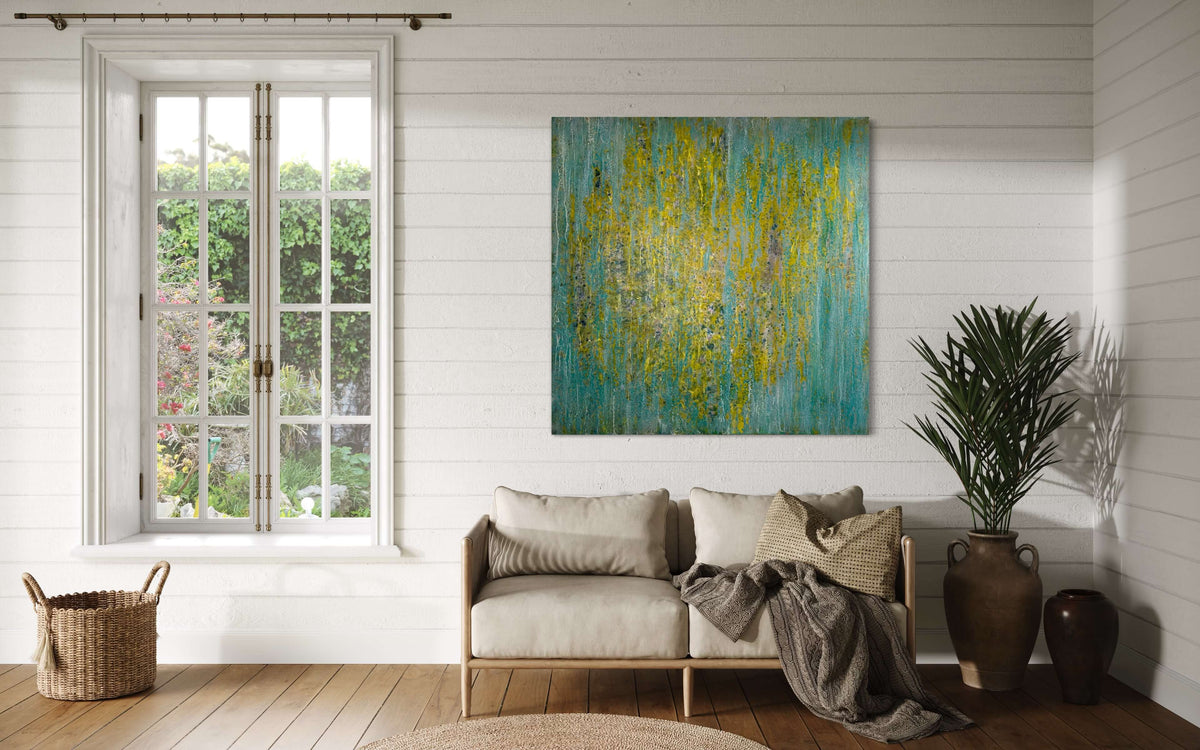 Original abstract encaustic painting in greens, yellows and blues with vertical textured layers displayed on a white wood panelled wall above a love seat.