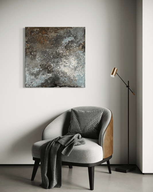 Original abstract painting with rust and corrosion pattern in blue, grey, white and silver tones with organic forms which make it seem like it is on a metal surface.
The painting is displayed above an armchair and floor lamp in modern interior