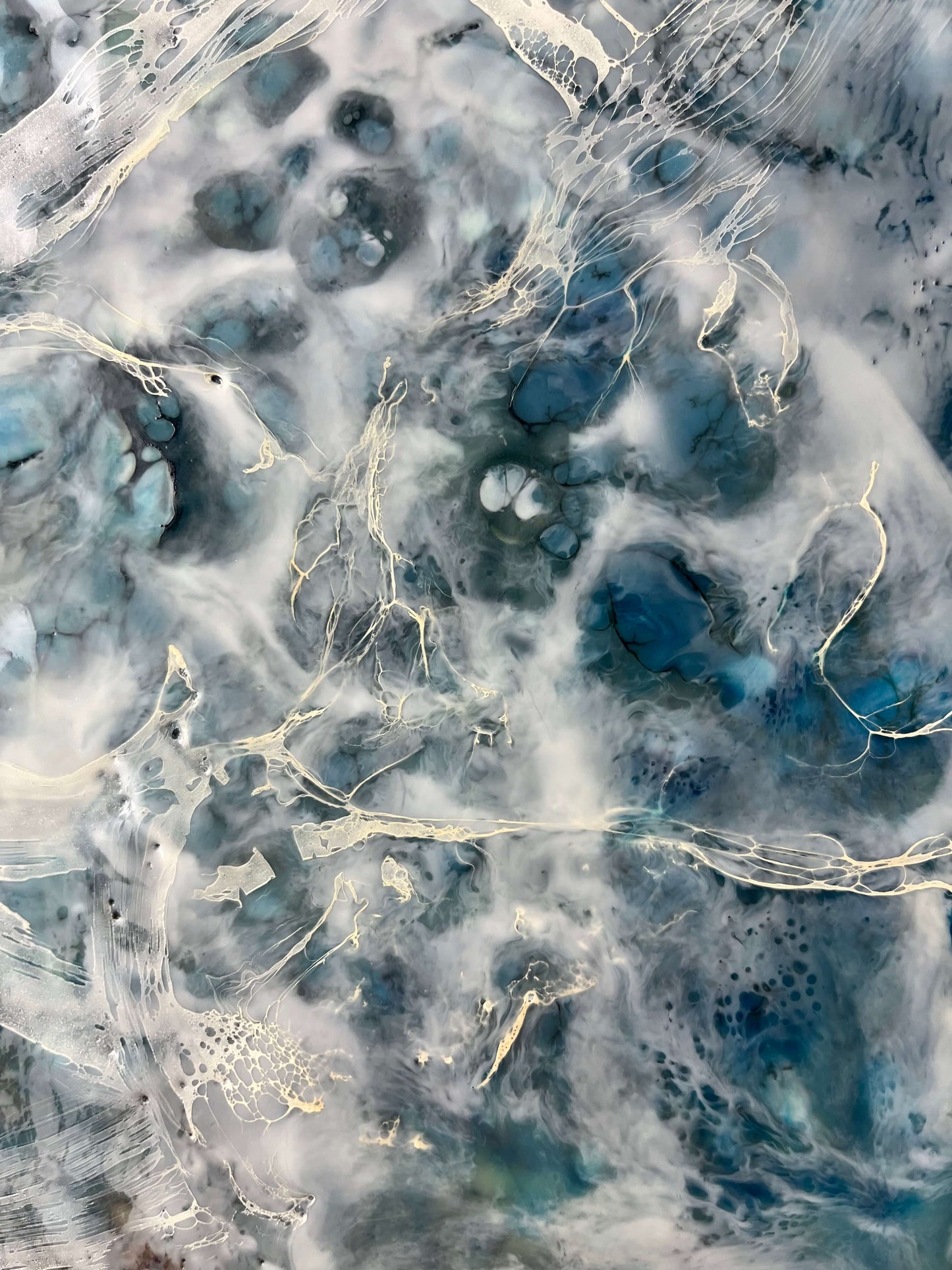 Close up.This abstract painting is created with encaustic medium and it is of the pair and it is inspired by a song written by Otis Redding. The painting is done in moody blues, whites and it has flow and movement to it to represent the movement of water