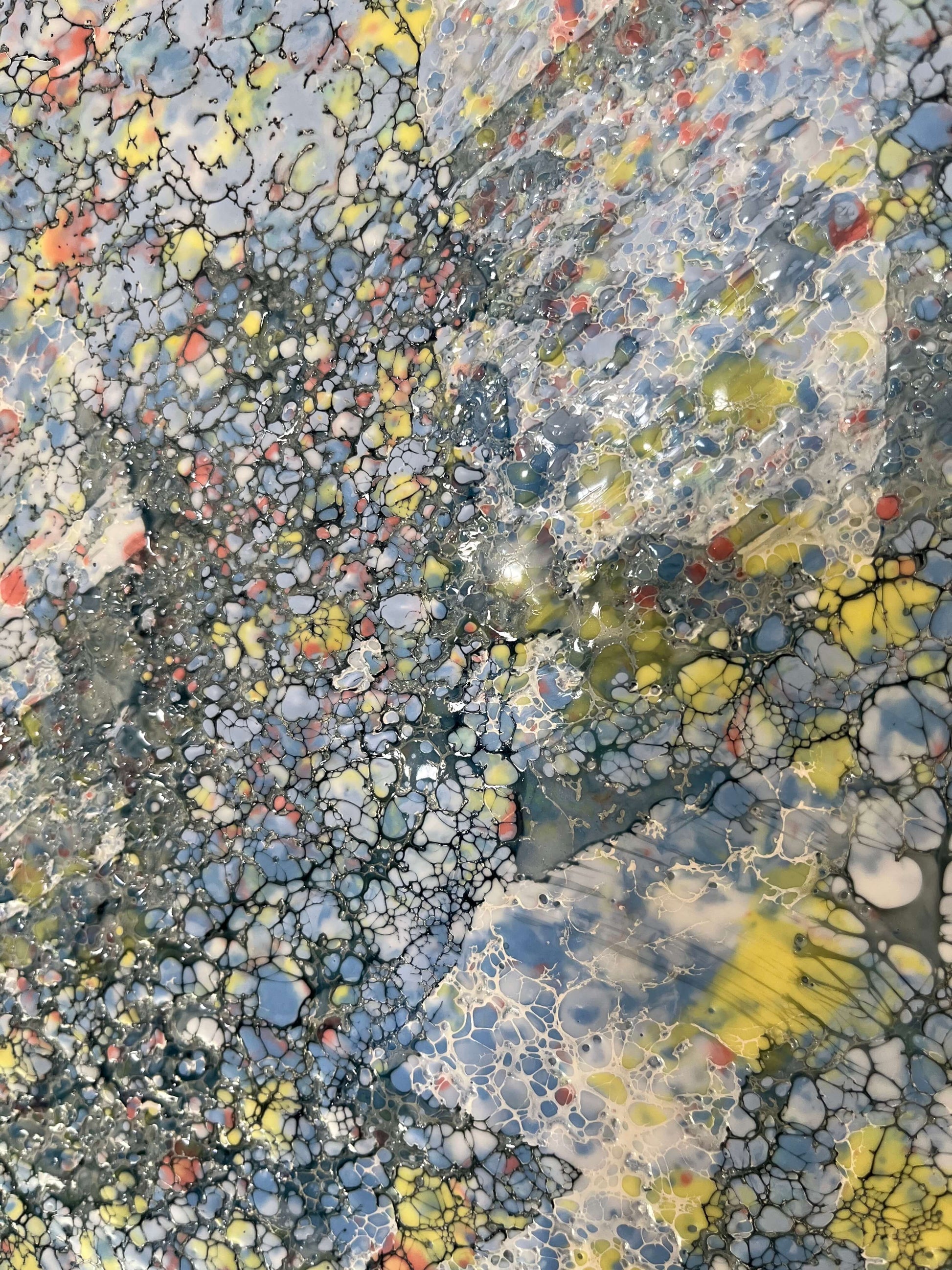 Close up.This piece has a very uplifting energy with its variations of blues, greys and specks of yellow and orange. it is a textured painting, when you run your fingers over it, you will feel ripples of wax. The droplets of orange wax signifies Monarch butterflies taking to the sky.