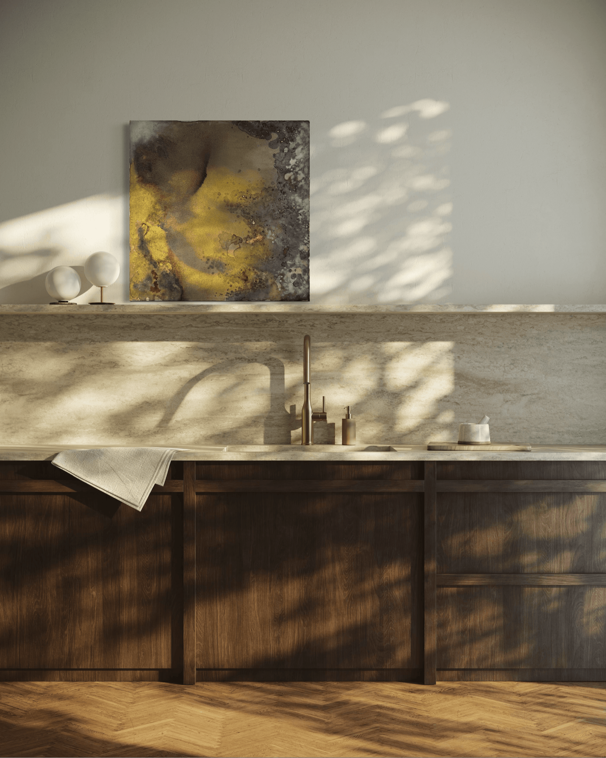 Original abstract painting with brown, rust, gold and grey tones with layered textures and organic forms displayed on a stone backsplash shelf  in modern kitchen interior
