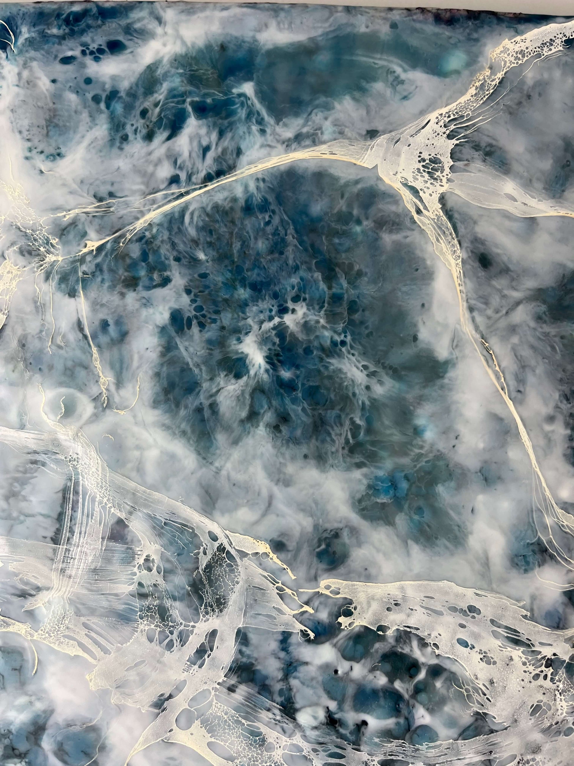 Close up.This abstract painting is created with encaustic medium and it is of the pair and it is inspired by a song written by Otis Redding. The painting is done in moody blues, whites and it has flow and movement to it to represent the movement of water