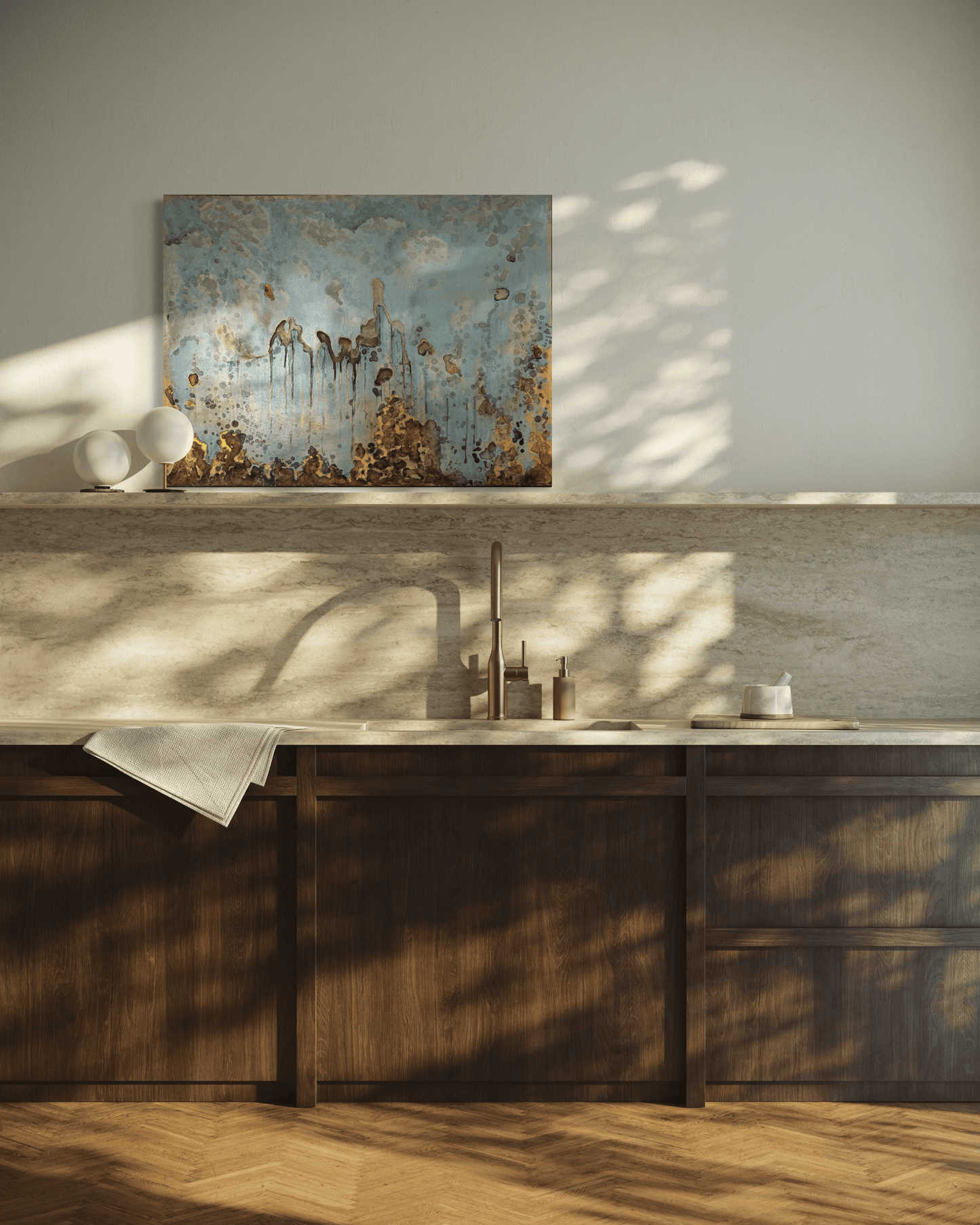 Original abstract painting in blue , gold and silvered with layered brown and rust textures and organic forms displayed on a stone backsplash shelve in modern kitchen interior.