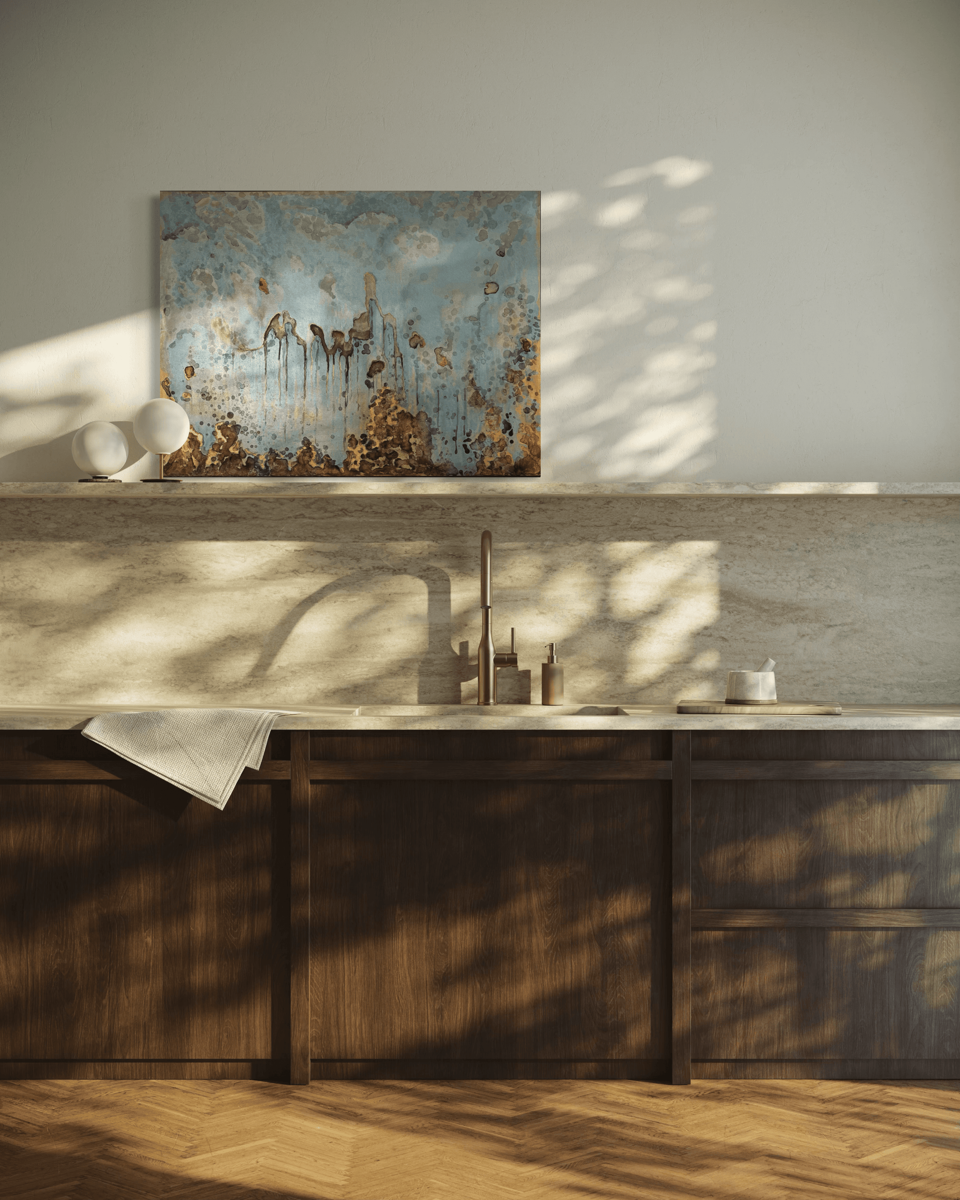 Original abstract painting in blue , gold and silvered with layered brown and rust textures and organic forms displayed on a stone backsplash shelve in modern kitchen interior.