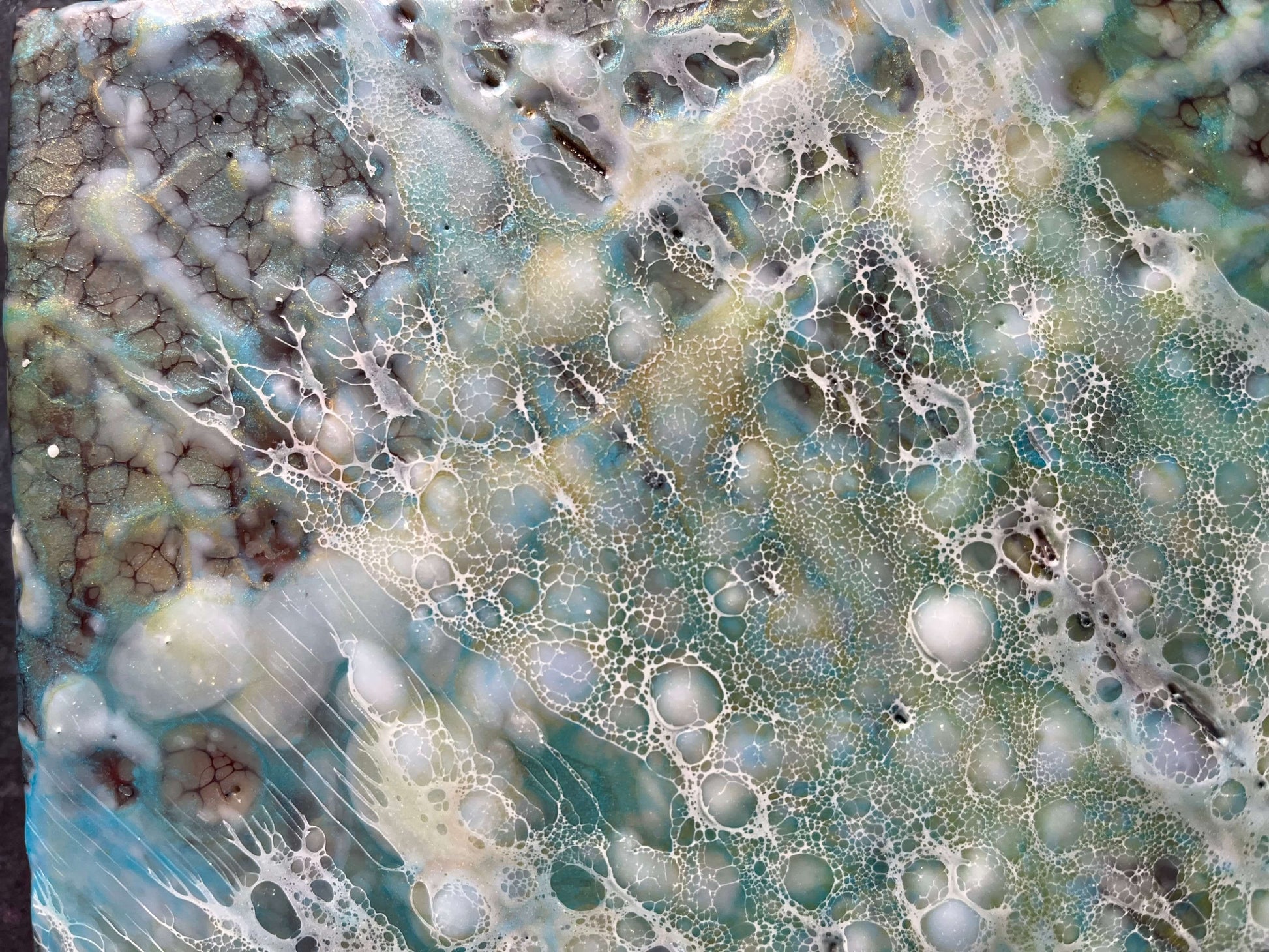 Close up.Abstract Encaustic Painting, 16x20in. Created with beeswax, damar resin, dry pigments and shellac on cradled wood panel. This painting is bursting with blues, greens and variations of earthy pigments. The delicate lace like texture of shellac mimics rain drops hitting the ground and creating tiny bubbles on the surface. Hanging hardware is included